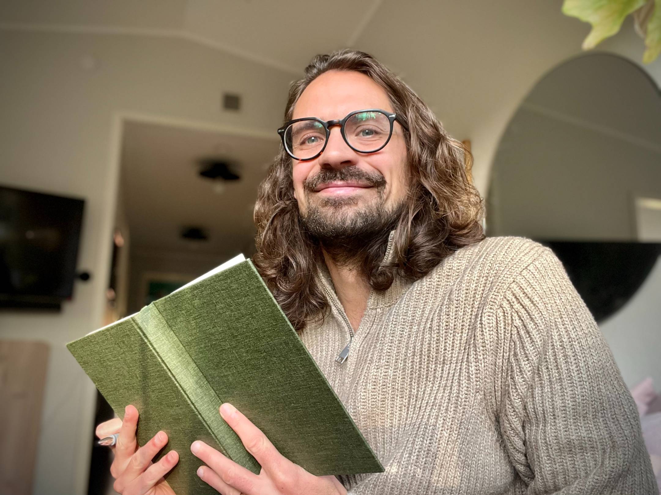 Christoffer Hiding med ett grönt anteckningsblock i handen